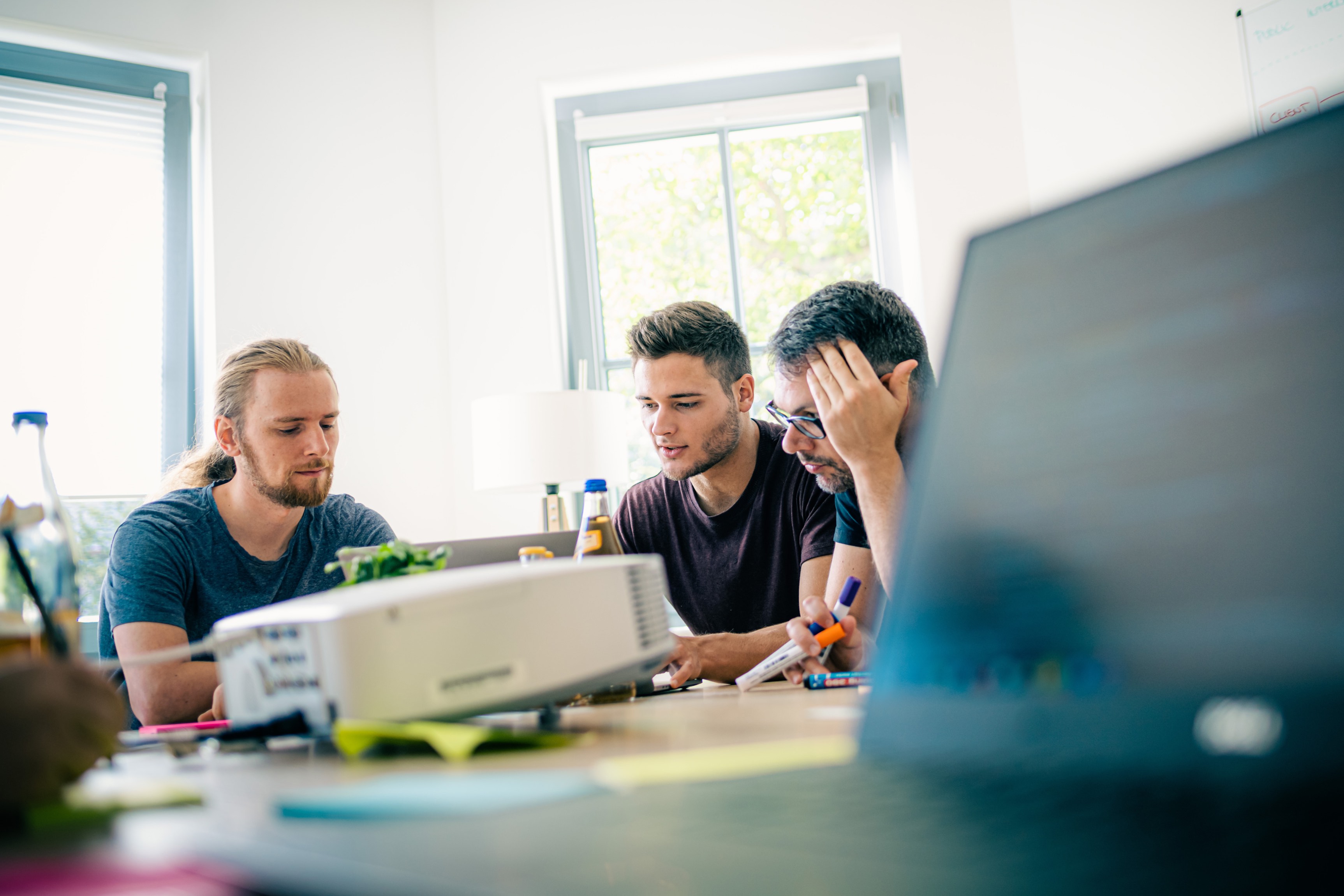 Team von Engineers in einer Besprechung über AI-Adoption, mit einem Whiteboard voller Diagramme und Notizen.